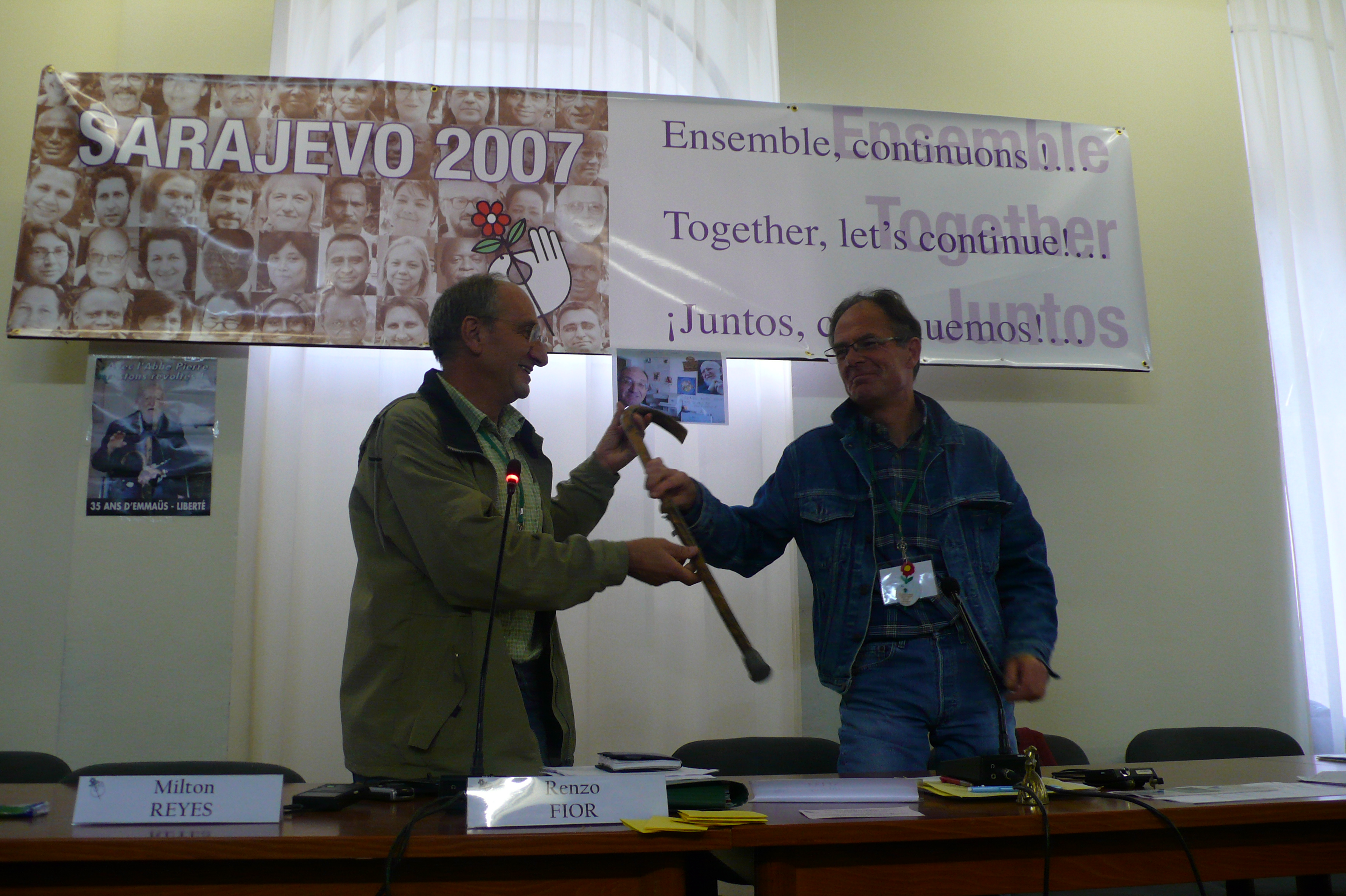 Photographie de Jean Rousseau recevant symboliquement la canne de l'abbé Pierre par Renzo Fior pour sa prise de fonction en tant que nouveau président de l'association, 2007.