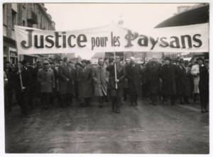 Cortège d’une manifestation portant une banderole « Justice pour les paysans » : photographie, sans lieu ni date.