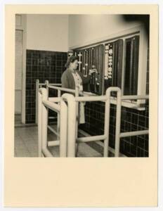 Une ouvrière textile range sa carte de pointage : photographie, vers 1955.
