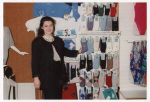 Une femme prend la pose devant un présentoir de vêtements Phildar : photographie, [années 1970-1980].