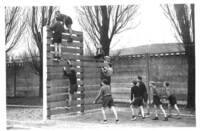 Un groupe de jeunes garçons franchissent un mur d'escalade (1946)