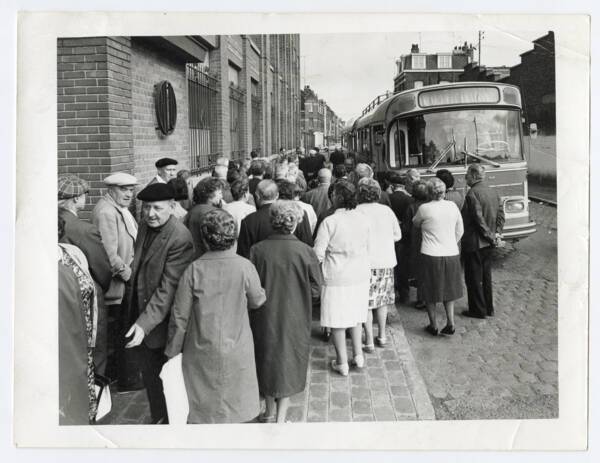 Entr&eacute;e avec groupe d'employ&eacute;s attendant de monter dans un bus.