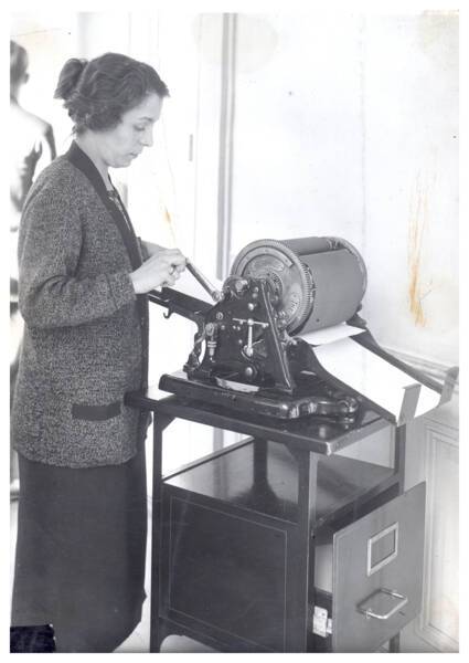 Une femme utilise un "Ron&eacute;ocopier" (machine servant &agrave; copier le courrier) : photographie, s.d. ANMT 2002 6 22, Ron&eacute;o (fabricant de duplicateurs, de mat&eacute;riels et mobilier bureau).